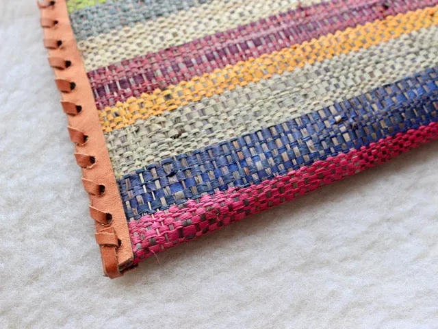 muted multi-colored striped raffia woven clutch with leather trim